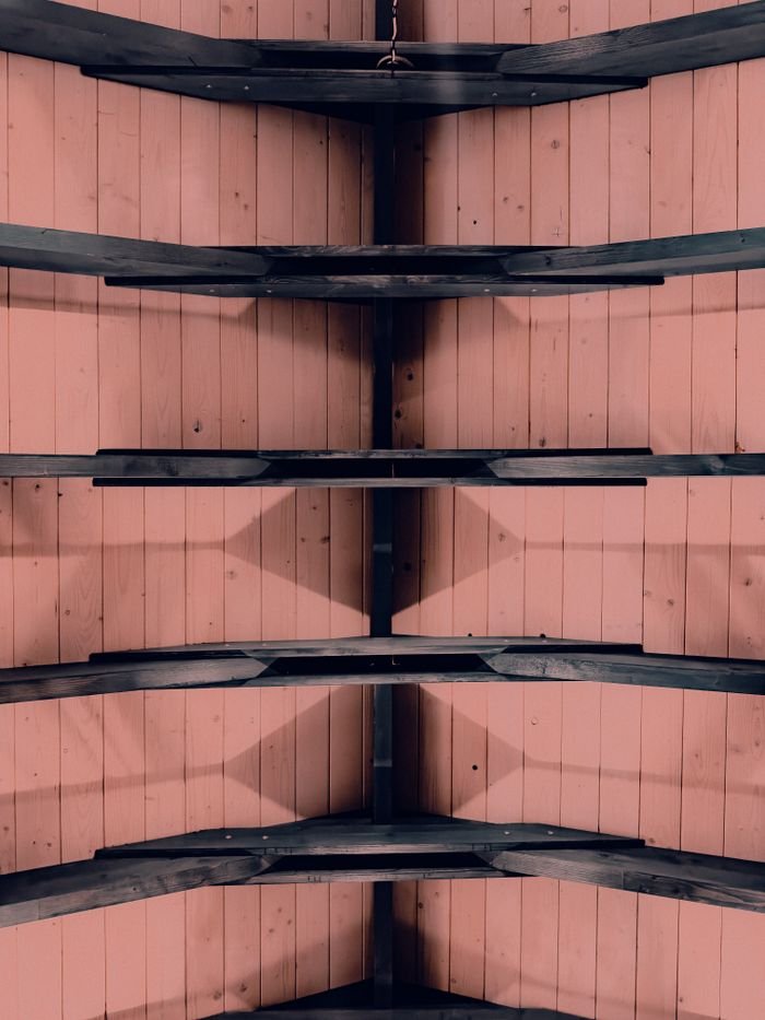 The Art of Drawing Readers In: Your attractive post title goes here Upward view of a wooden ceiling with black beams creating a symmetrical pattern.